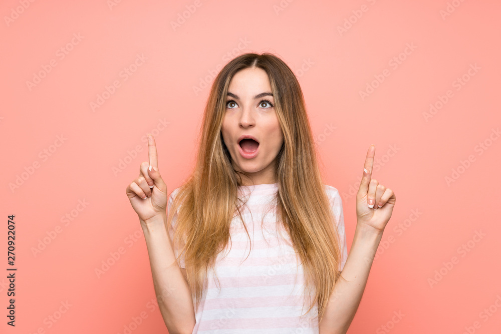Obraz premium Young woman over isolated pink wall pointing with the index finger a great idea