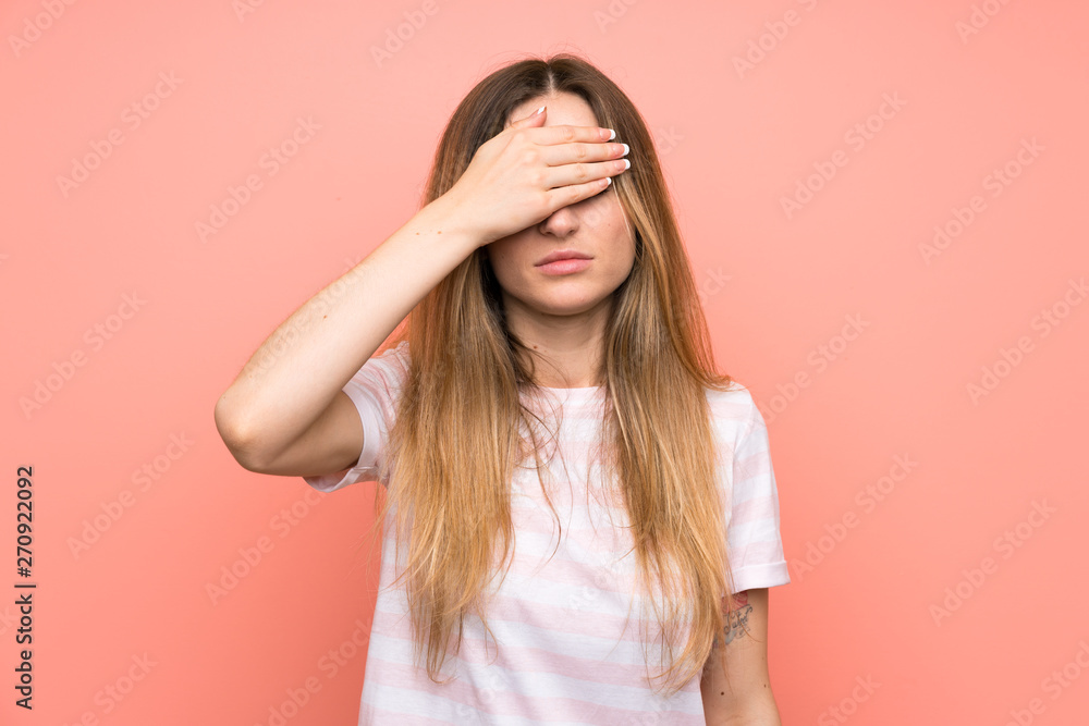 Young woman over isolated pink wall covering eyes by hands Young woman over isolated pink wall covering eyes by hands