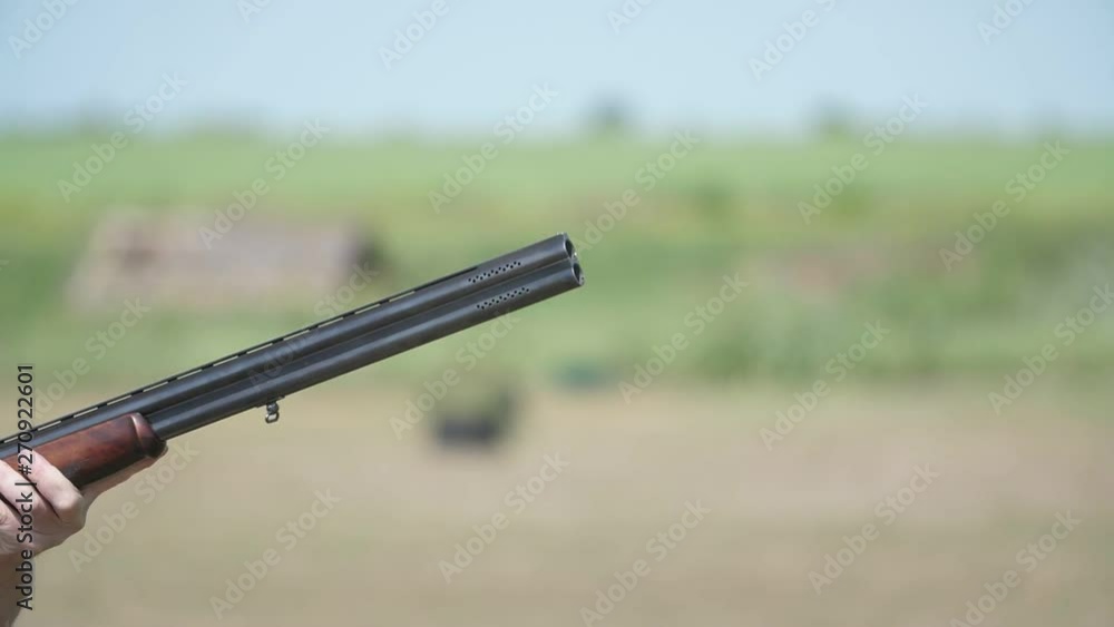 Sportive over and under gun firing and aiming clay targets on a range in slo-mo Sportive over and under gun firing and aiming clay targets on a range in slo-mo