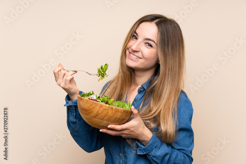 Young woman with salad over isolated background