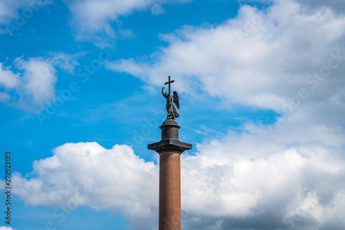 Angel on the Alexandrian pillar in St. Petersburg against the blue sky with white clouds