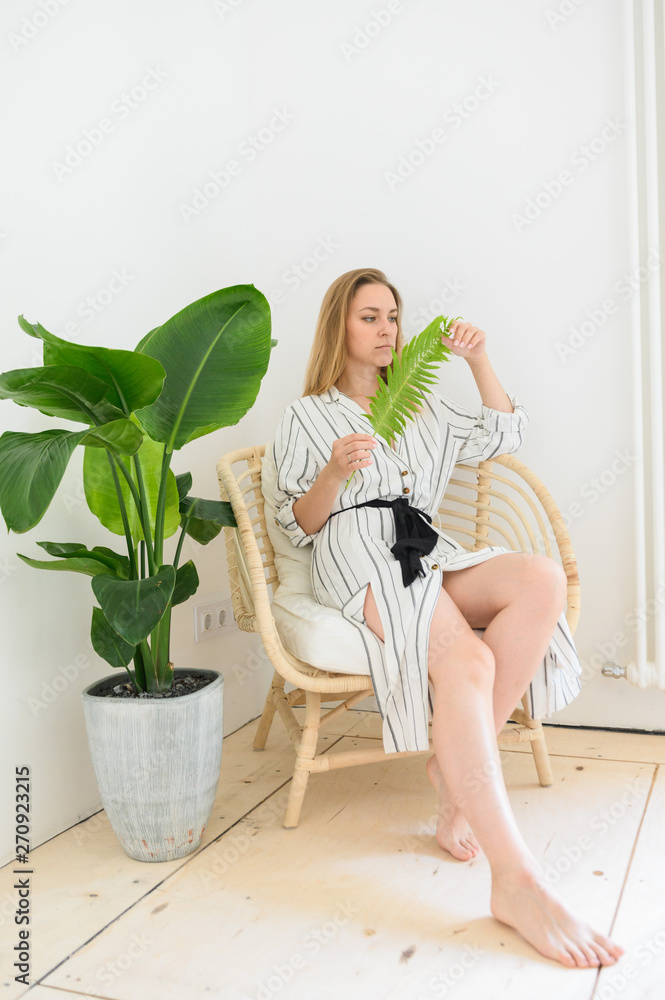 Beautiful girl sitting in a bright room with flower Beautiful girl sitting in a bright room with flower