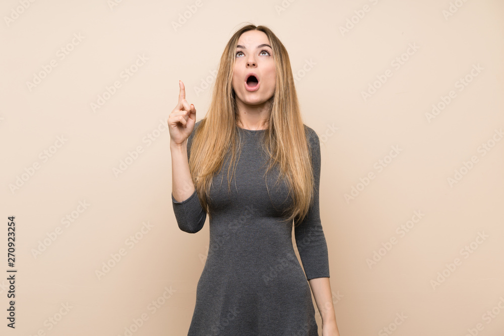 Young woman over isolated background pointing up and surprised Young woman over isolated background pointing up and surprised