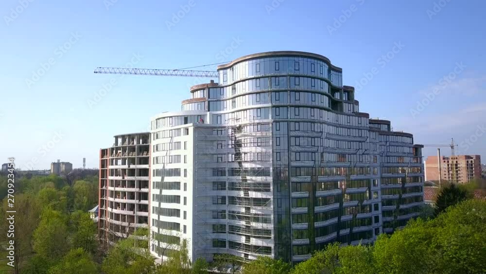 Aerial view of high modern residential building and tower crane under construction. Aerial view of high modern residential building and tower crane under construction.