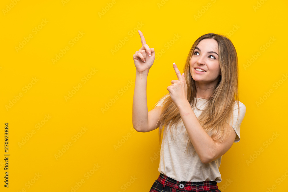 Young woman over isolated yellow wall pointing with the index finger a great idea Young woman over isolated yellow wall pointing with the index finger a great idea
