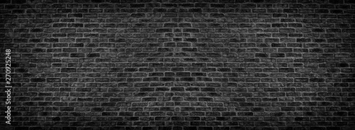 Wide black brick wall texture. Old rough brickwork panorama. Dark panoramic background
