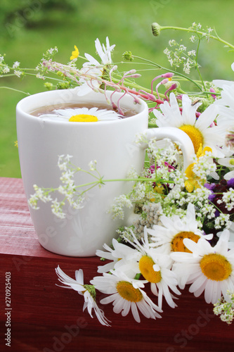A cup of tea with daisies bouquet 