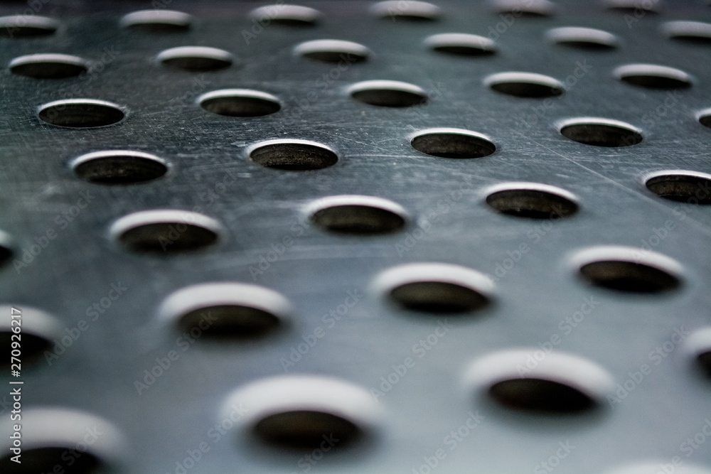 Background or texture from a gray and monophonic metal surface with symmetric and round openings. Background or texture from a gray and monophonic metal surface with symmetric and round openings.