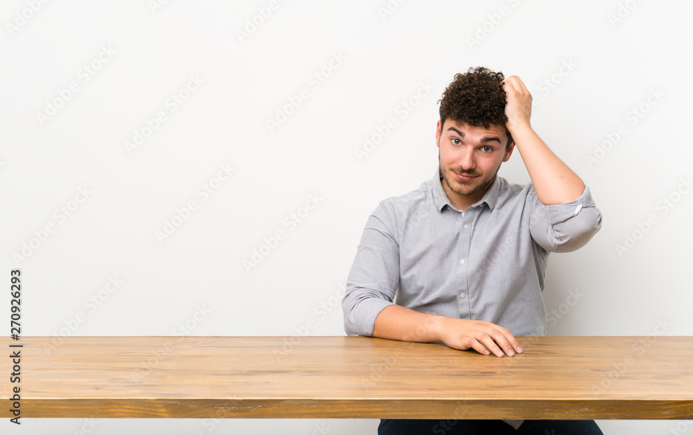 Young man with a table with an expression of frustration and not understanding Young man with a table with an expression of frustration and not understanding