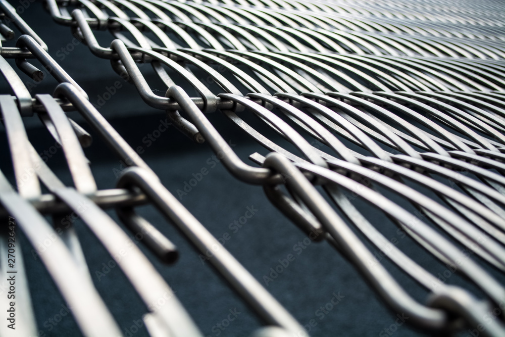 Background or texture on a gray wall a lattice from metal a wire which intertwine among themselves. Hooks and loops. Geometry of lines. Background or texture on a gray wall a lattice from metal a wire which intertwine among themselves. Hooks and loops. Geometry of lines.
