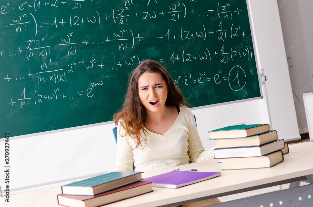 Young female math teacher in front of chalkboard Young female math teacher in front of chalkboard
