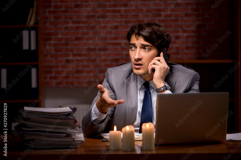 Businessman working late in office with candle light Businessman working late in office with candle light