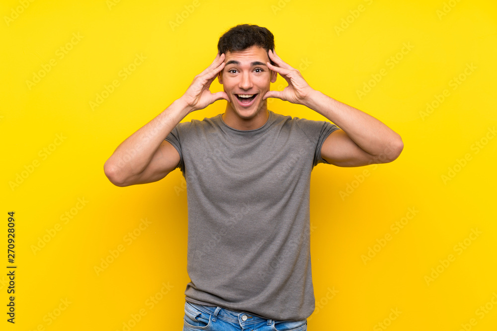 Fototapeta premium Handsome man over isolated yellow wall with surprise expression