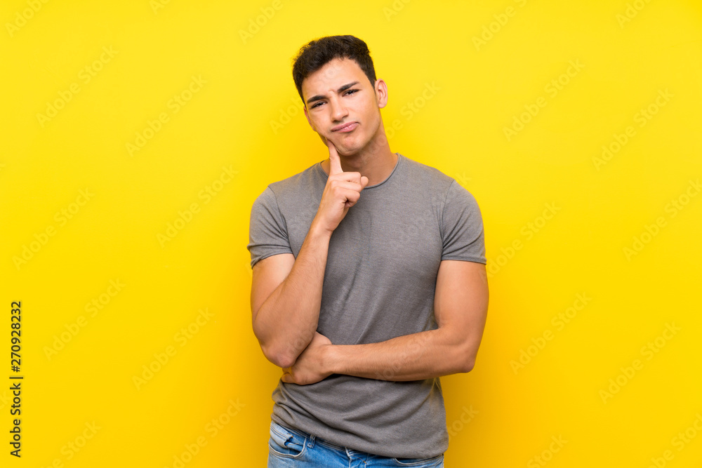 Handsome man over isolated yellow wall Looking front Handsome man over isolated yellow wall Looking front