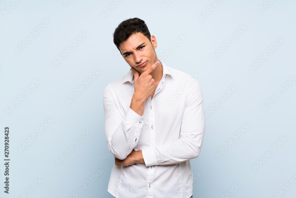 Handsome man over blue wall thinking Handsome man over blue wall thinking