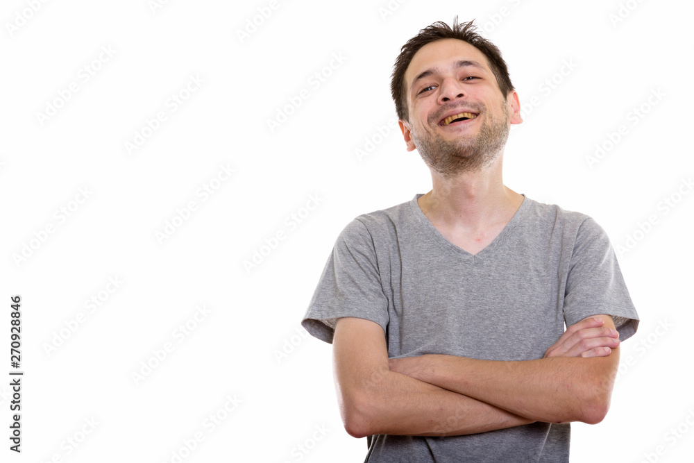 Fototapeta premium Studio shot of happy young man smiling and laughing with arms cr