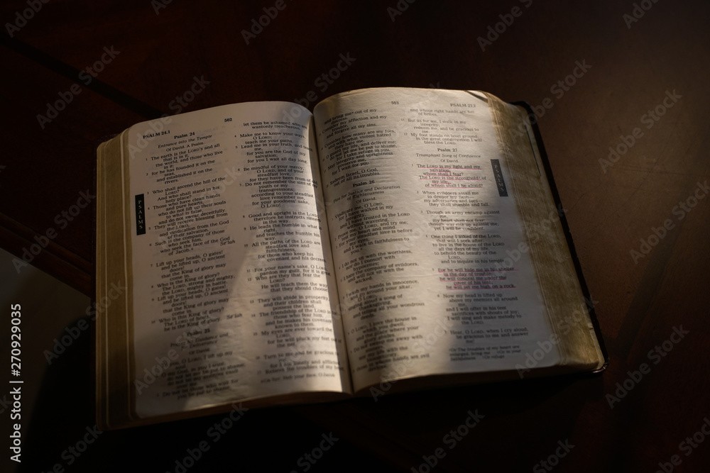Fototapeta premium Open bible on a dark wood table