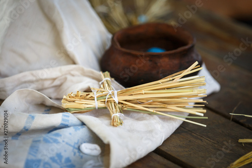 Figure of a man made of straw lies on a white cloth on the table photo