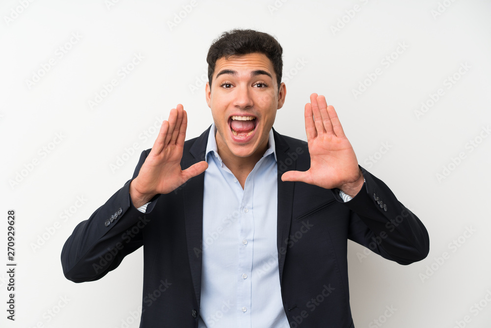 Handsome man over isolated white wall shouting with mouth wide open Handsome man over isolated white wall shouting with mouth wide open