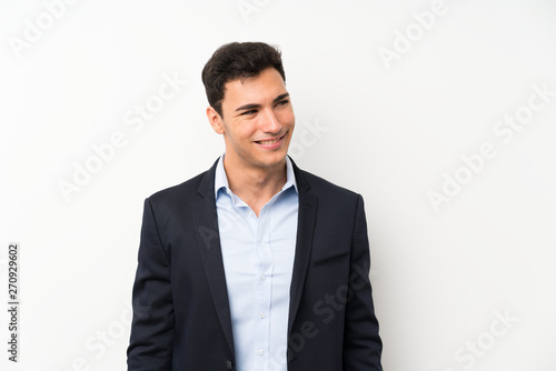 Handsome man over isolated white wall standing and looking to the side