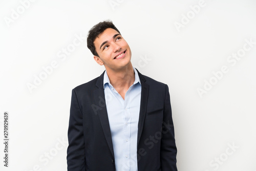Handsome man over isolated white wall laughing and looking up