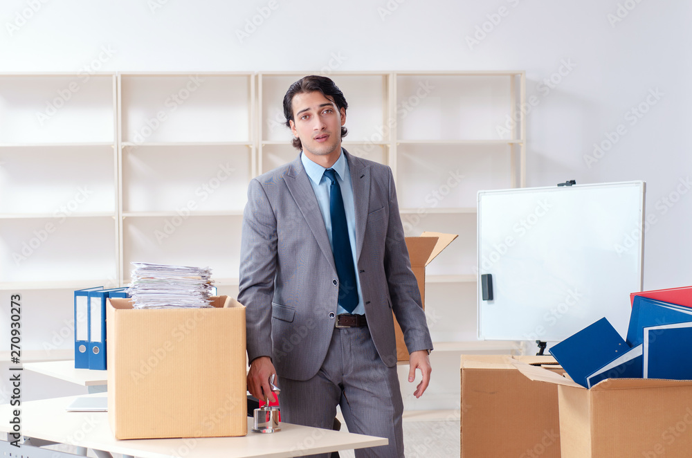 Young man employee with boxes in the office Young man employee with boxes in the office