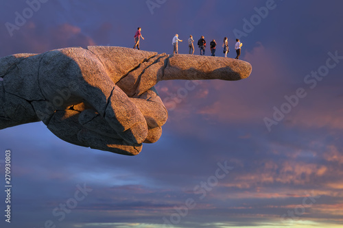 group of people standing on a big hand pointing to nowhere photo