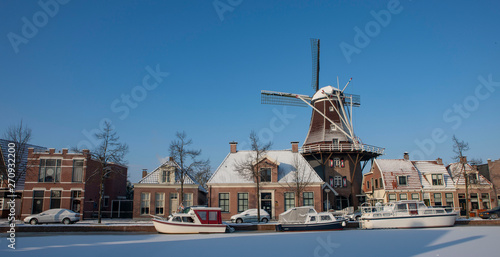 Winter in the city of Meppel drente Netherlands. Windmill de Vlijt. Sluisgracht. Snow and ice. Frozen canal.