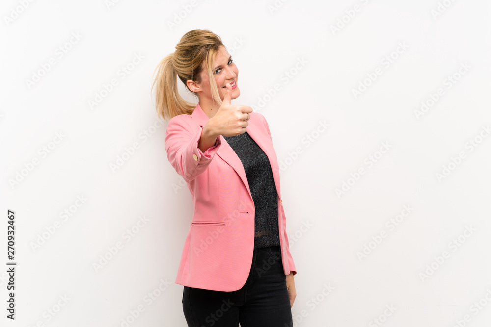 Young blonde woman with pink suit with thumbs up because something good has happened Young blonde woman with pink suit with thumbs up because something good has happened