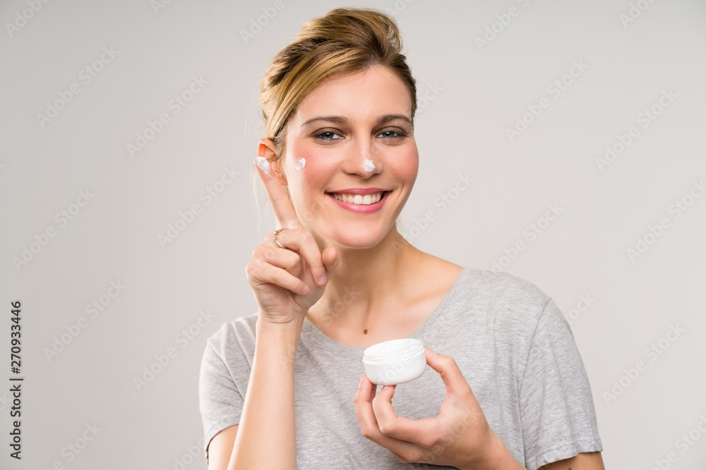 Young blonde woman with makeup brush with moisturizer Young blonde woman with makeup brush with moisturizer