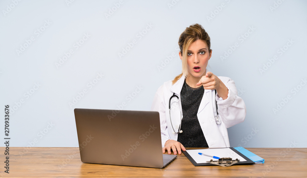 Blonde doctor woman surprised and pointing front Blonde doctor woman surprised and pointing front