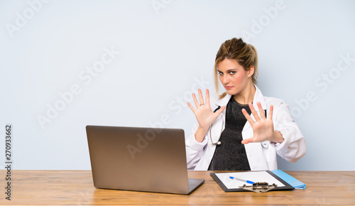 Blonde doctor woman nervous stretching hands to the front