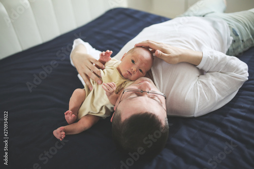 Newborn with dad on dark sheet, father with baby © natalialeb