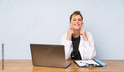 Blonde doctor woman smiling with a happy and pleasant expression