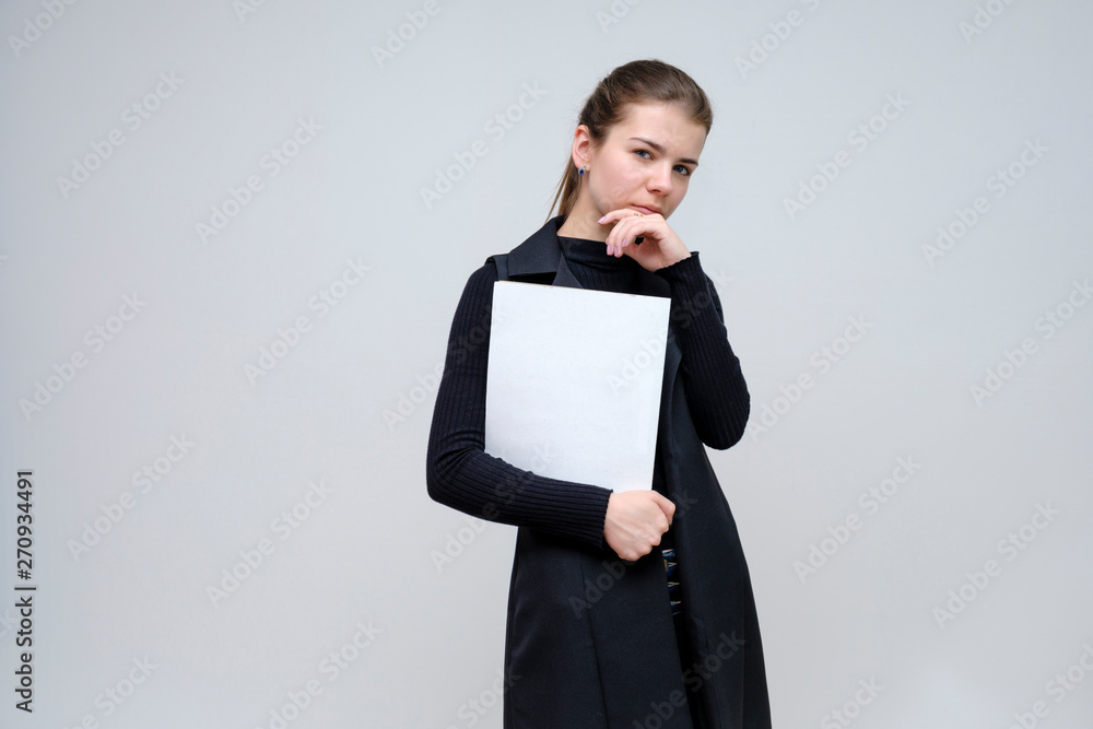 Photo portrait of a beautiful smiling brunette business woman with a folder on a white background in a black business suit with long beautiful dark hair in the studio. Photo portrait of a beautiful smiling brunette business woman with a folder on a white background in a black business suit with long beautiful dark hair in the studio.