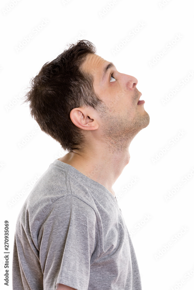 Profile view of young man thinking while looking up Profile view of young man thinking while looking up