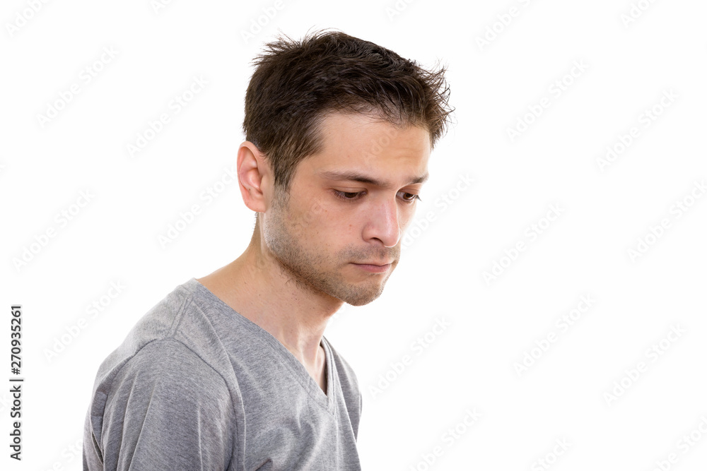 Studio shot of sad young man looking down Studio shot of sad young man looking down