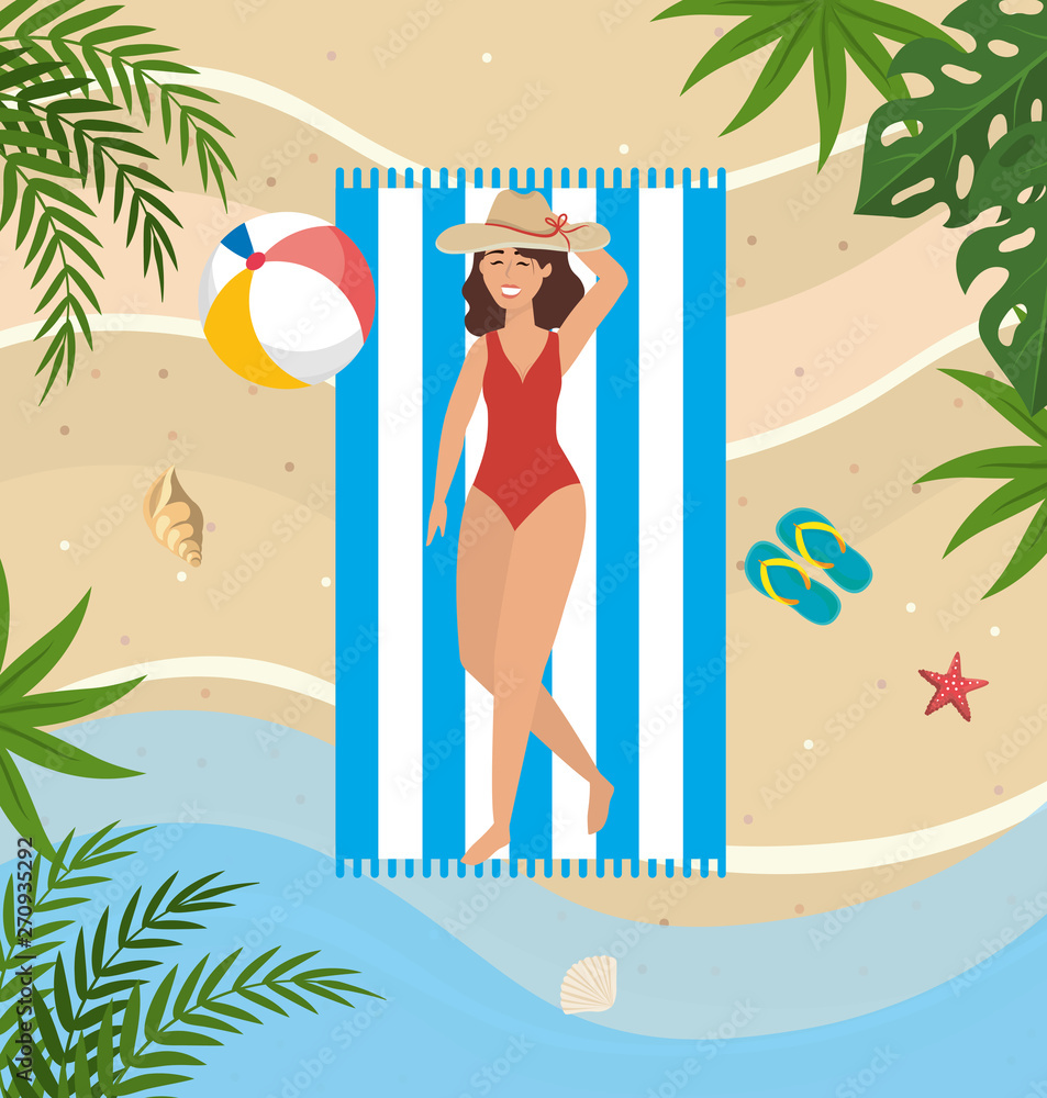 woman taking sun with hat and beach ball in the towel