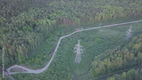 Aerial Powerful power lines ENERGY over the forest, the city of St. Petersburg at sunset photo