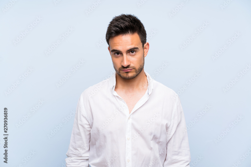 Handsome young man over isolated blue background with sad and depressed expression Handsome young man over isolated blue background with sad and depressed expression