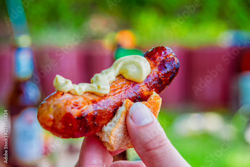Bratwurst with mustard in a small bread roll