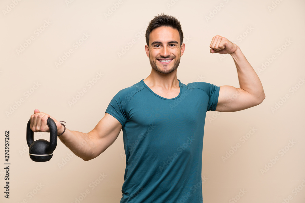 Handsome sport man over isolated background with kettlebell Handsome sport man over isolated background with kettlebell