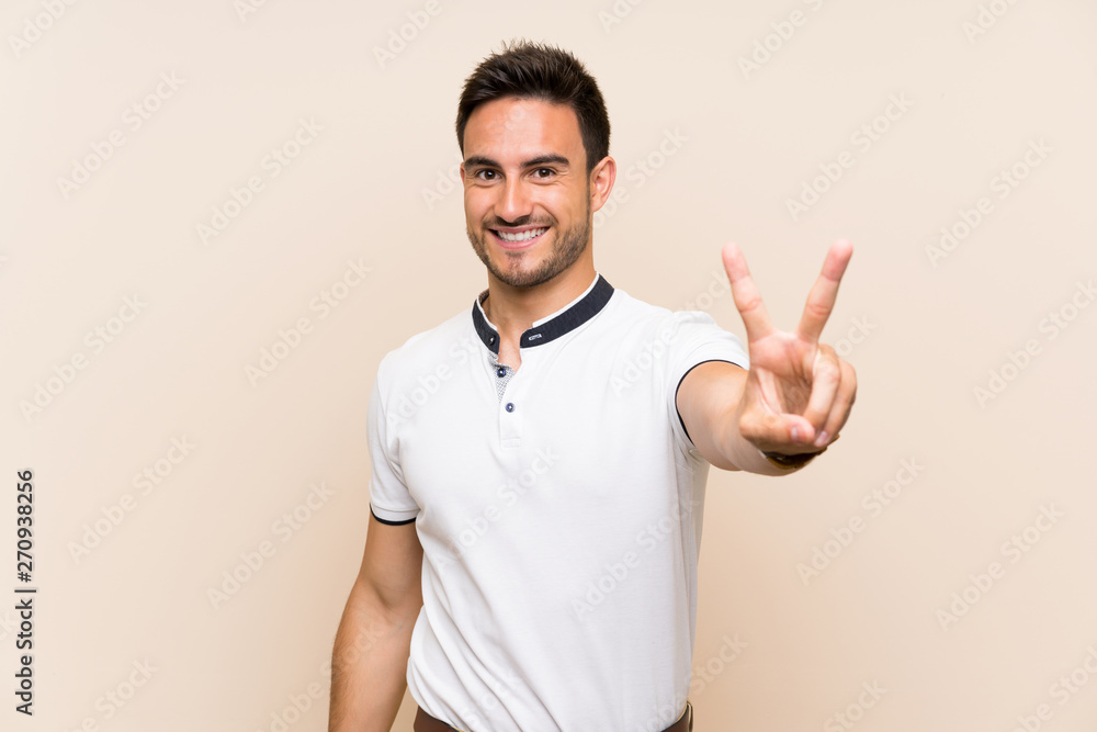 Handsome young man over isolated background smiling and showing victory sign Handsome young man over isolated background smiling and showing victory sign