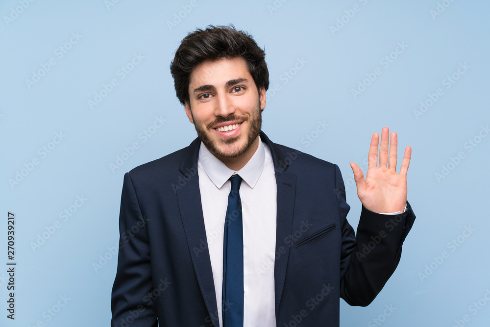 Businessman over isolated blue wall saluting with hand with happy expression Businessman over isolated blue wall saluting with hand with happy expression