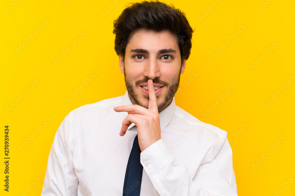 Businessman on isolated yellow background doing silence gesture Businessman on isolated yellow background doing silence gesture