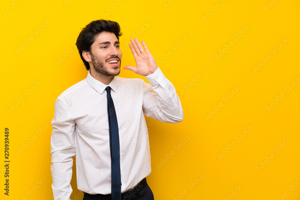 Businessman on isolated yellow background shouting with mouth wide open Businessman on isolated yellow background shouting with mouth wide open