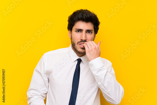 Businessman on isolated yellow background nervous and scared