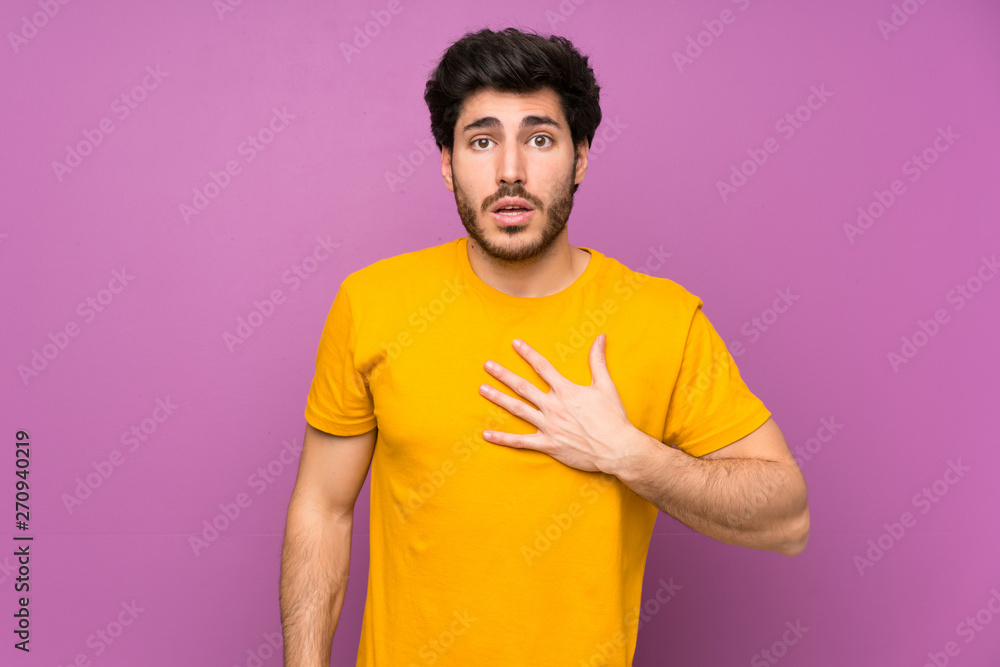 Handsome over isolated purple wall surprised and shocked while looking right Handsome over isolated purple wall surprised and shocked while looking right