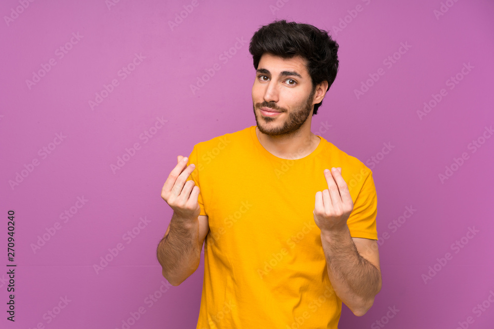 Handsome over isolated purple wall making money gesture Handsome over isolated purple wall making money gesture