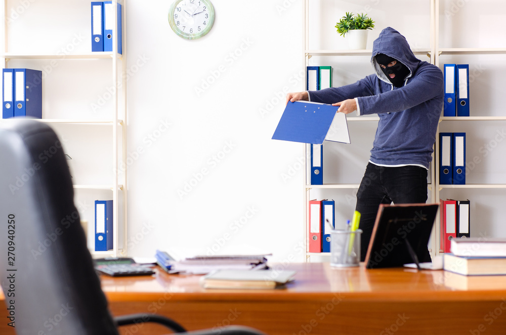 Male thief in balaclava in the office Male thief in balaclava in the office